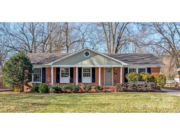 Brick ranch house with a well-maintained lawn and mature trees at 941 Squirrel Hill Rd, Charlotte, NC 28213