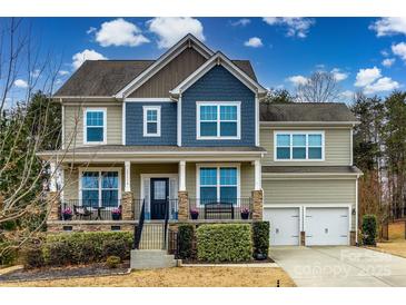 Two-story house with gray and blue siding, stone accents, and a two-car garage at 17114 Belmont Stakes Ln, Charlotte, NC 28278