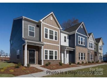 Two-story townhome with gray and tan siding, and a black front door at 1104 Verdigris Dr, Gastonia, NC 28054