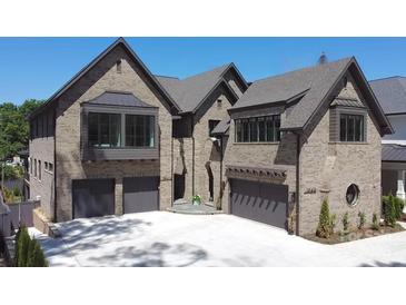 Beautiful brick home featuring a three-car garage and manicured landscaping at 1214 S Kings Dr # A, Charlotte, NC 28207