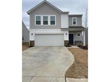 Two-story house featuring a gray exterior, white garage door, and a small front yard at 202 Brentwood Dr, Statesville, NC 28625