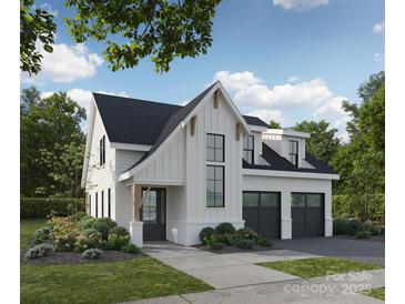 Stunning two-story white farmhouse-style home featuring a black roof, attached two-car garage, and beautifully landscaped front yard at 2728 Ritz Ln, Matthews, NC 28105