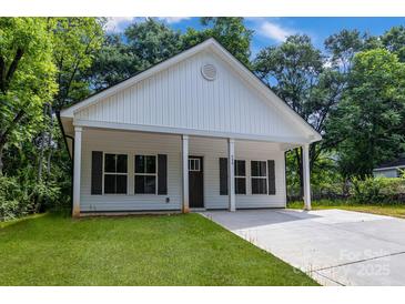 Charming single-story home featuring a covered porch and a well-manicured front yard at 408 N Boyd St, Gastonia, NC 28052