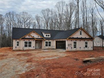 New construction home showcasing a single-story facade with an attached garage in a wooded lot at 609 Shiloh Unity Rd, Lancaster, SC 29720