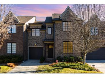 A charming two-story townhome with a landscaped yard, garage, and a warm and inviting entrance at 6411 Aldworth Ln, Charlotte, NC 28226