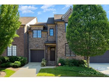 Charming brick townhome featuring an attached garage and manicured front lawn at 6411 Aldworth Ln, Charlotte, NC 28226