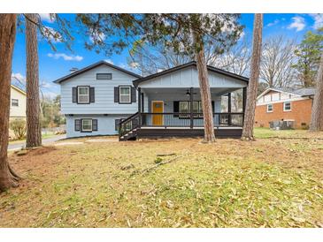 Ranch style home features a light blue exterior, black accents, and a covered porch at 1001 Archdale Dr, Charlotte, NC 28217