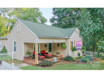 Charming single-story home featuring a cozy front porch with red cushioned chairs and landscaped yard at 2407 Brookside Ave, Kannapolis, NC 28081