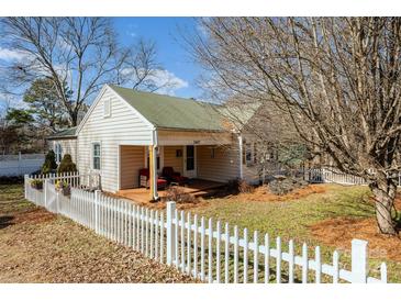 Charming home with a welcoming front porch, cozy seating, and a classic white picket fence at 2407 Brookside Ave, Kannapolis, NC 28081