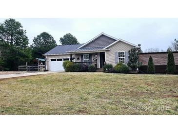 Ranch style home with attached garage and landscaped lawn at 249 Planters Row Rd, Iron Station, NC 28080