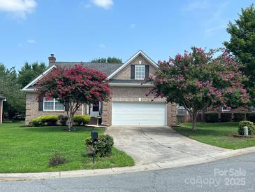 Brick ranch home with attached garage and landscaped yard at 2509 Calgary Pl, Concord, NC 28027