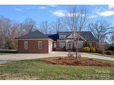 Brick home with a three-car garage and landscaped lawn at 2635 Queens Dr, Lincolnton, NC 28092