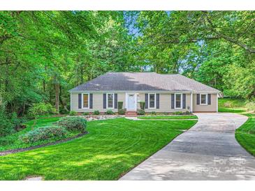Charming home featuring a lush green lawn, complemented by mature trees and a well-maintained landscape at 4145 Wall St, Charlotte, NC 28209