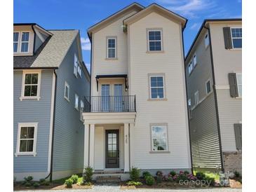 Charming two-story home with a front porch and balcony on a sunny day at 425 Delburg Mill Alley Dr, Davidson, NC 28036