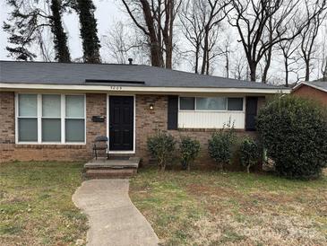 Brick ranch house with a black door, landscaping, and walkway at 5009 Highlake Dr, Charlotte, NC 28215