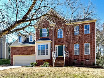 Brick two-story house with a large front yard and attached garage at 7780 Orchard Park Cir, Harrisburg, NC 28075