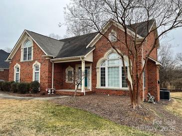 Brick house with a large front yard and mature trees at 7925 Tottenham Dr, Harrisburg, NC 28075