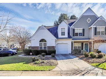 Two-story townhome with gray and white siding, attached garage, and landscaped yard at 8927 Bryant Field Cir, Charlotte, NC 28277