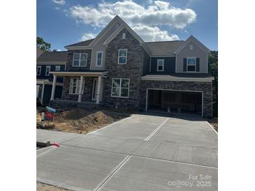 New two-story home with stone and siding, an attached garage, and a concrete driveway at 147 Holsworthy Dr, Mooresville, NC 28115