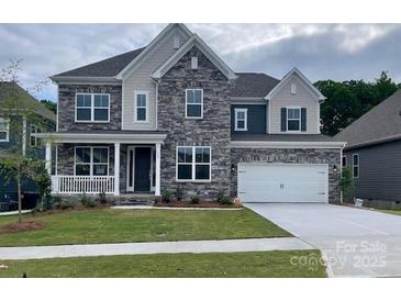 Charming two-story home featuring a stone facade, covered porch, and two-car garage at 147 Holsworthy Dr, Mooresville, NC 28115