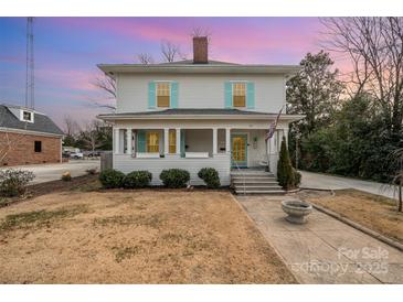 Charming two-story home with a welcoming front porch and cheerful blue shutters at 132 N Confederate Ave, Rock Hill, SC 29730