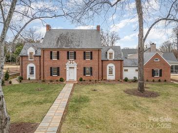 Charming brick home with a slate roof, black shutters, and manicured lawn, exuding classic elegance and curb appeal at 2400 Mecklenburg Ave, Charlotte, NC 28205