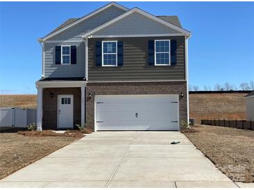 Charming two-story home featuring a brick and siding facade, a two-car garage, and a well-maintained lawn at 301 Brinkley Dr # Lot 103, Kings Mountain, NC 28086