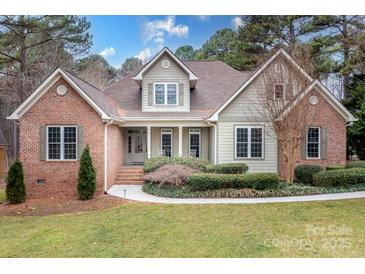 Charming brick and siding home with manicured lawn and beautiful landscaping at 302 Mccrary Rd, Mooresville, NC 28117
