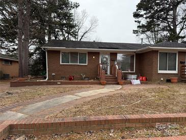 Brick ranch home with landscaped yard and walkway at 4718 Americana Ave, Charlotte, NC 28215