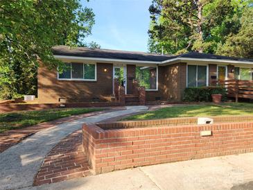 Brick ranch home with landscaped yard and walkway at 4718 Americana Ave, Charlotte, NC 28215