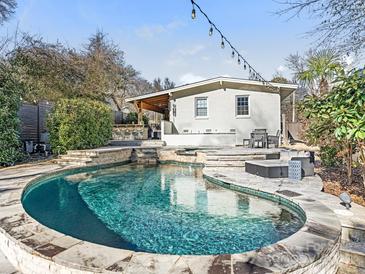 Inviting pool with spacious stone patio and outdoor kitchen at 1408 Edgewater Dr, Charlotte, NC 28210