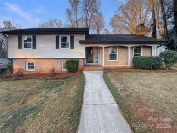 Brick ranch house with a landscaped yard and walkway at 1601 Lyndale Pl, Charlotte, NC 28210