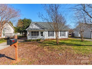 White house with gray roof, front porch, and landscaped yard at 210 Lauren Dr, Indian Trail, NC 28079