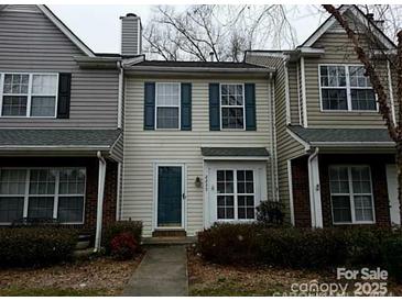 Two-story townhome with gray siding, green door, and landscaping at 2237 Cigar Ct, Charlotte, NC 28273