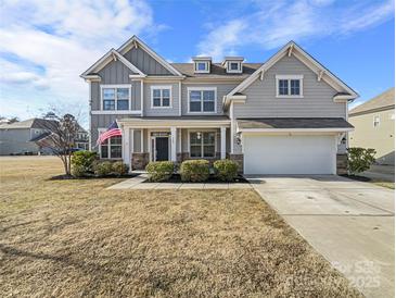 Two-story house with gray siding, stone accents, and a two-car garage at 368 Pleasant Hill Se Dr, Concord, NC 28025