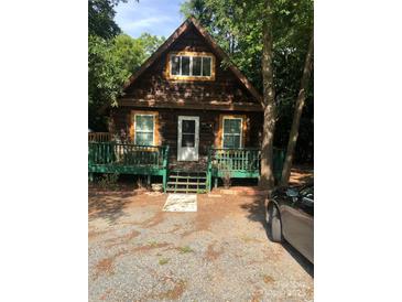 A charming A-frame cabin nestled in woods with a deck at 503 Welsh Ave, Monroe, NC 28112