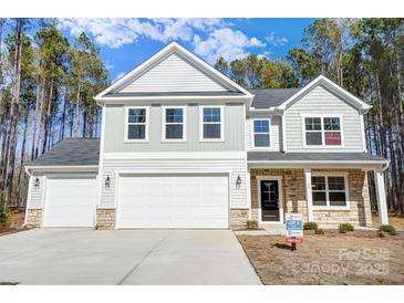 Two-story house with gray and white siding, stone accents, and a three-car garage at 5763 Crown Ter, Hickory, NC 28601