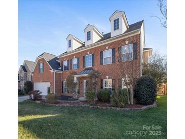 Brick home with dormer windows and landscaped lawn at 8440 Mossy Cup Trl, Harrisburg, NC 28075