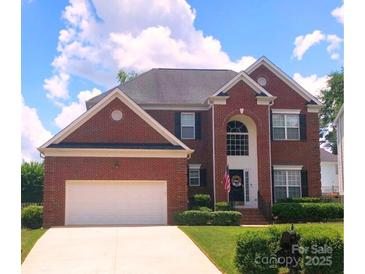 Brick two-story home with attached garage and landscaped lawn at 10409 Kilchurn Ct, Charlotte, NC 28277