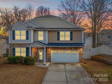 Charming two-story home boasts stone accents, attached two-car garage, and well-maintained landscaping at 1120 Spicewood Pines Rd, Fort Mill, SC 29708