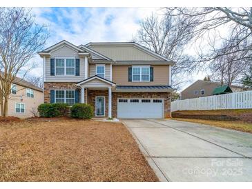 Two-story house with stone and siding, a large driveway and landscaped yard at 1120 Spicewood Pines Rd, Fort Mill, SC 29708