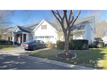 White exterior home with a two-car garage and manicured lawn at 12111 Frogs Leap Ct, Charlotte, NC 28277