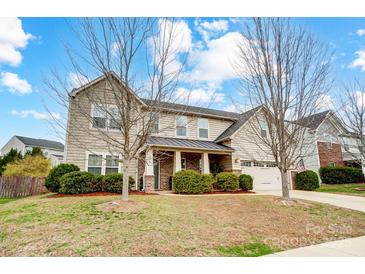 Charming two-story home featuring a welcoming front porch and well-maintained landscaping with mature trees at 2065 Taney Way, Fort Mill, SC 29707