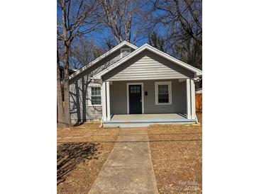 Charming one-story home featuring a covered front porch and tidy landscaping at 238 Coxe Ave, Charlotte, NC 28208