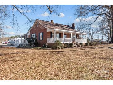 Brick ranch house with a front porch, situated on a spacious lot with mature trees at 2614 S Us 321 Hwy, Newton, NC 28658