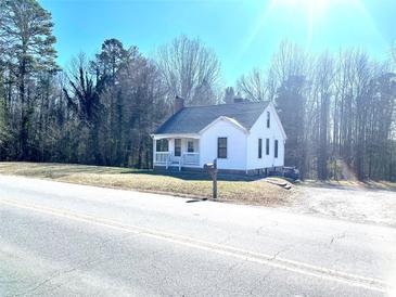 White house with a wraparound porch and mature trees at 2704 Kool Park Ne Rd, Hickory, NC 28601