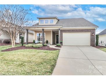 Charming single-Gathering home featuring a brick facade, covered porch, attached two-car garage, and well-maintained landscaping at 6248 Raven Rock Dr, Denver, NC 28037