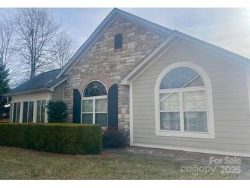 Attractive home with stone and siding accents, arched windows, and manicured landscaping at 758 Ledgestone Ct, Tega Cay, SC 29708