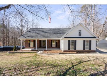 Charming ranch-style home featuring a covered front porch, black shutters, and a manicured lawn at 888 Brevard Place Rd, Iron Station, NC 28080