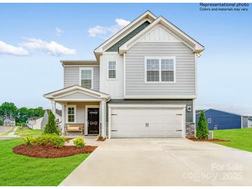 Charming two-story home featuring a covered porch, two-car garage, and beautifully landscaped front yard at 11027 Daisy Ct, Charlotte, NC 28262